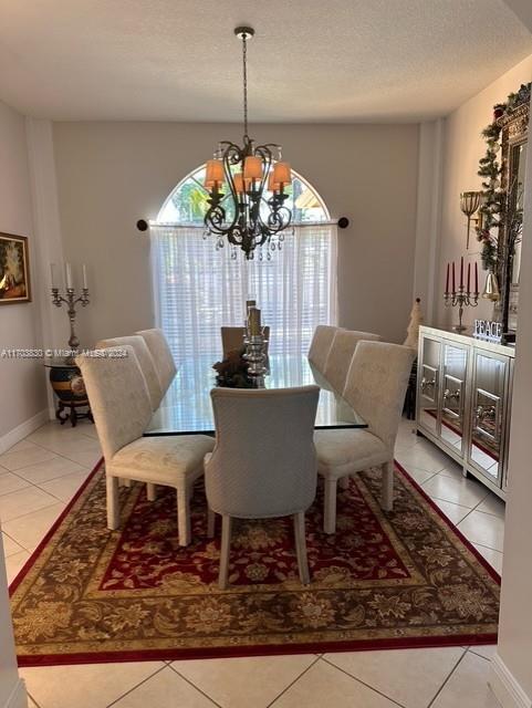 dining room featuring light tile patterned floors, a textured ceiling, and a chandelier