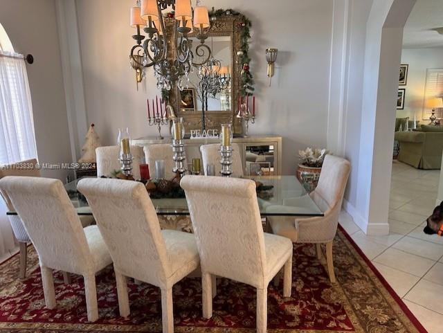 tiled dining room featuring a chandelier