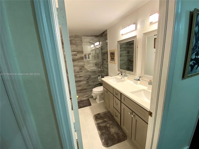 bathroom with tiled shower, vanity, tile patterned floors, and toilet