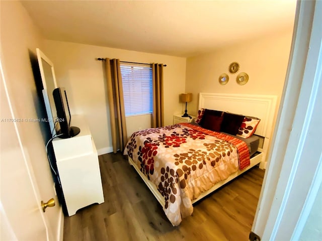 bedroom with dark hardwood / wood-style flooring