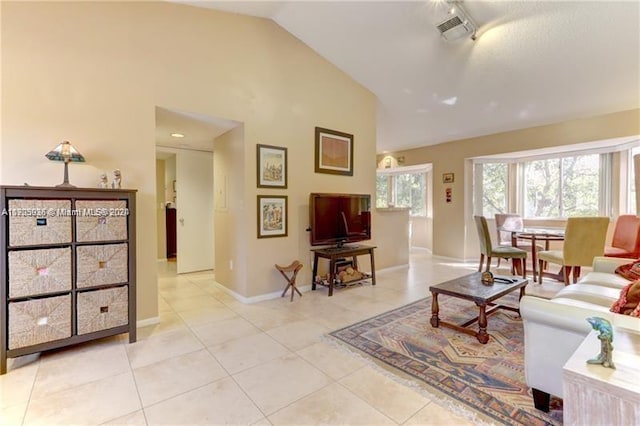 living room featuring light tile patterned floors and high vaulted ceiling