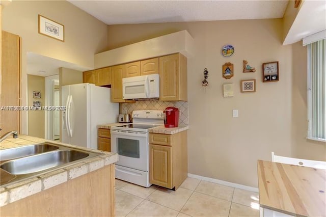 kitchen featuring white appliances, vaulted ceiling, sink, light brown cabinets, and light tile patterned flooring