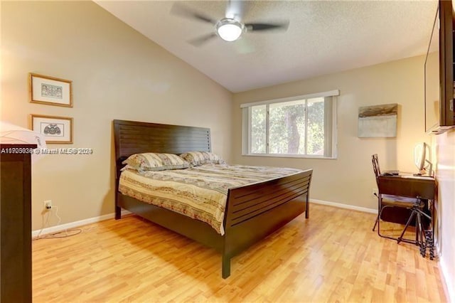 bedroom with ceiling fan, light wood-type flooring, and vaulted ceiling