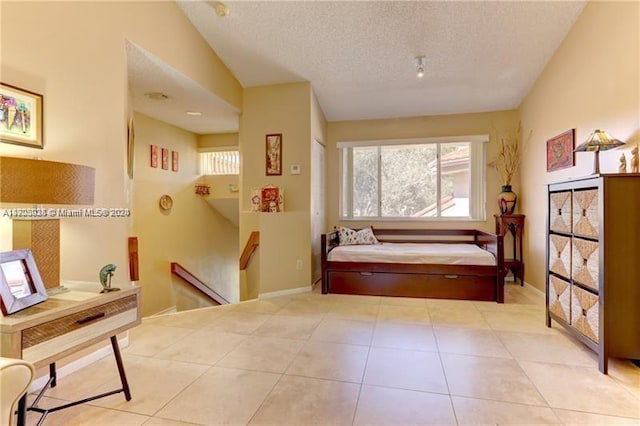 sitting room with lofted ceiling, light tile patterned floors, a textured ceiling, and a baseboard radiator