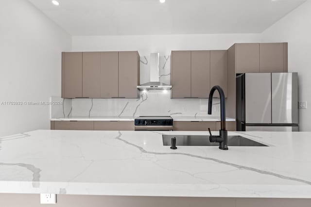 kitchen with backsplash, sink, wall chimney exhaust hood, gray cabinets, and appliances with stainless steel finishes