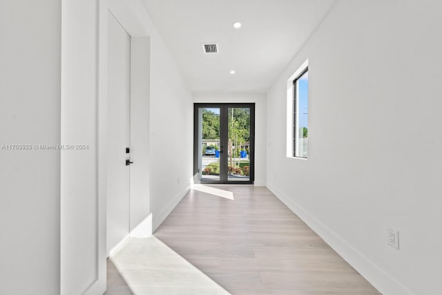 hall featuring french doors and light hardwood / wood-style floors