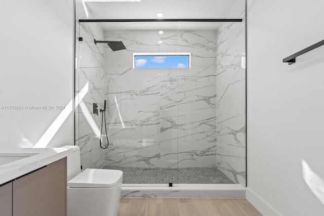 bathroom featuring tiled shower, vanity, and toilet