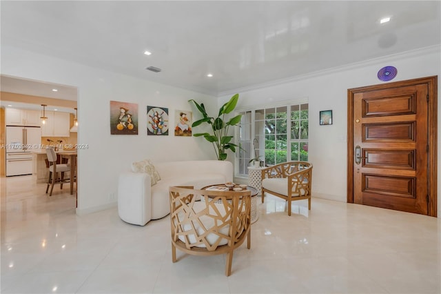 living area featuring light tile patterned floors and crown molding