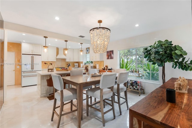 dining space with light tile patterned floors and an inviting chandelier