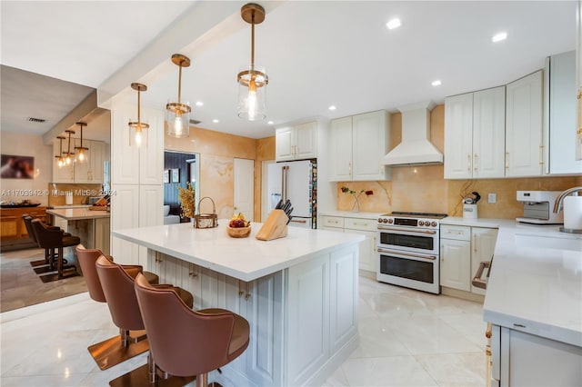 kitchen featuring white cabinetry, hanging light fixtures, premium range hood, white fridge, and range with two ovens