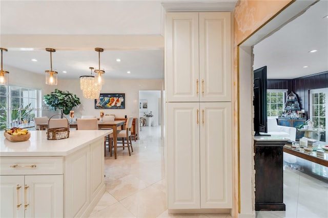 kitchen featuring white cabinets, a healthy amount of sunlight, light tile patterned flooring, and pendant lighting