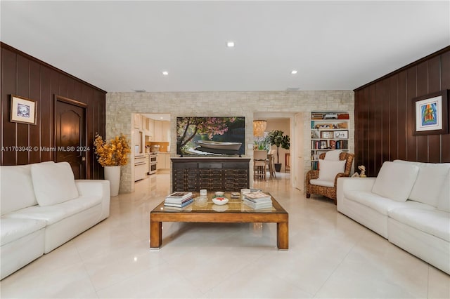 living room with wood walls and crown molding