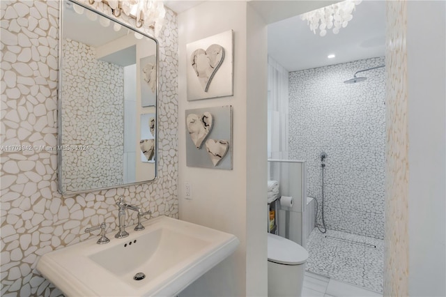 bathroom with sink, tile patterned floors, toilet, tiled shower, and decorative backsplash