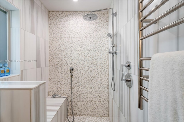 bathroom with tiled shower and tile walls