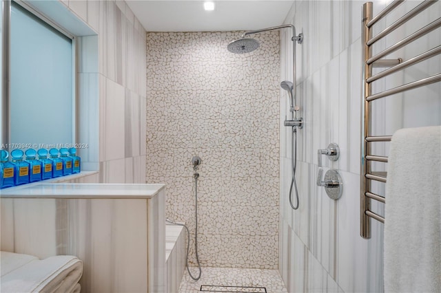 bathroom featuring a tile shower, tile patterned floors, and tile walls