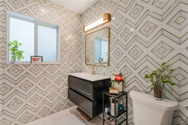 bathroom featuring vanity, toilet, and a wealth of natural light