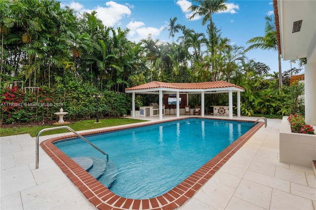 view of swimming pool with a gazebo, a patio area, and exterior kitchen