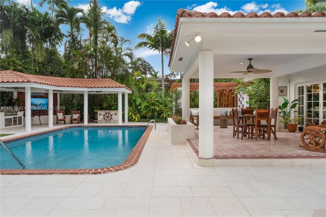 view of swimming pool with ceiling fan and a patio area