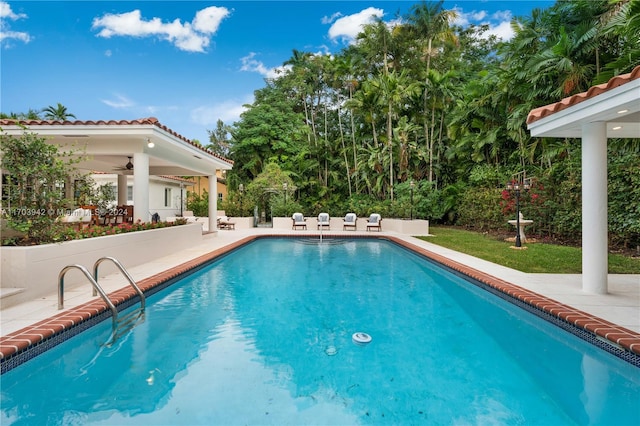 view of pool with ceiling fan and a patio