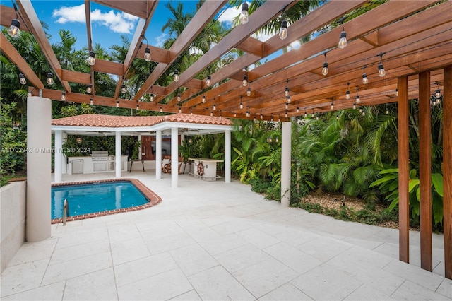 view of swimming pool with a pergola, an outdoor kitchen, and a patio area