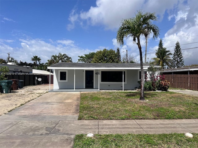 view of front of house with fence, a front lawn, and stucco siding