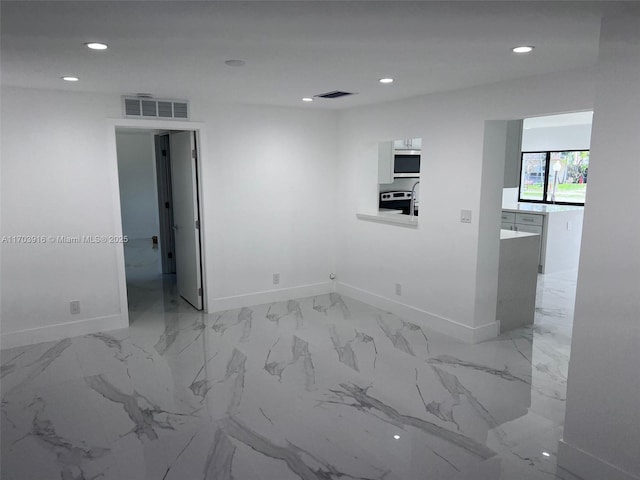 spare room featuring baseboards, visible vents, and recessed lighting