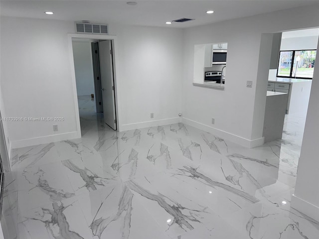 spare room featuring baseboards, visible vents, and recessed lighting