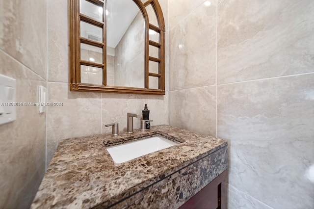 bathroom with vanity and tile walls