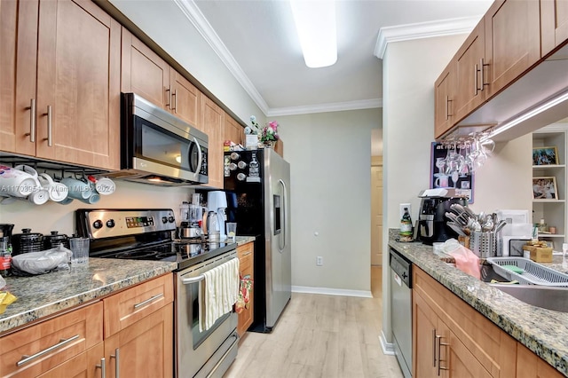 kitchen with ornamental molding, light wood-type flooring, stone countertops, and appliances with stainless steel finishes