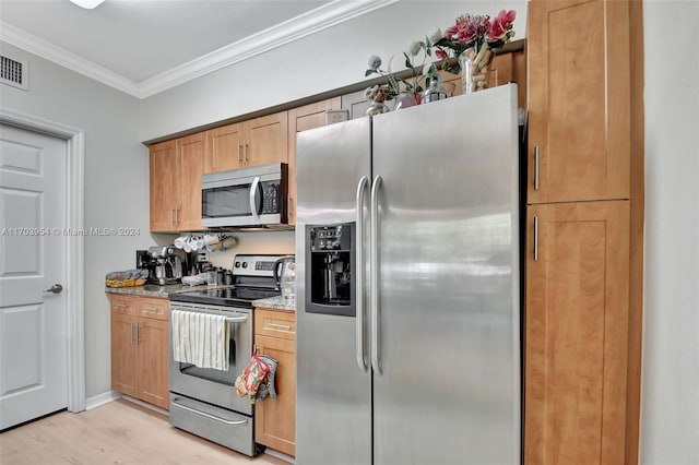 kitchen with appliances with stainless steel finishes, light hardwood / wood-style flooring, light stone counters, and crown molding