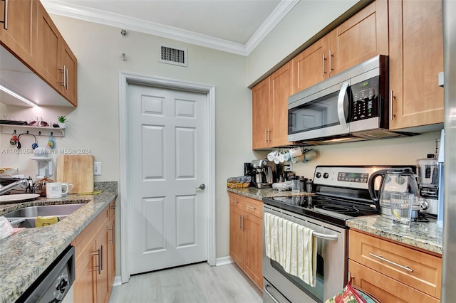 kitchen featuring light stone countertops, light wood-type flooring, stainless steel appliances, crown molding, and sink