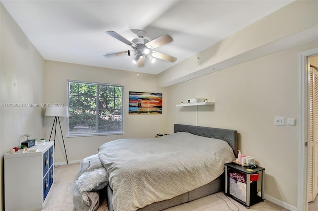 carpeted bedroom with ceiling fan and a closet