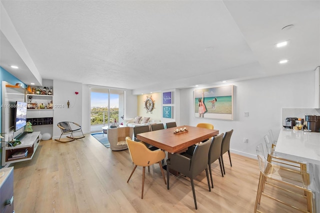 dining area featuring light hardwood / wood-style floors and a textured ceiling