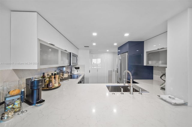 kitchen with blue cabinetry, white cabinetry, sink, and stainless steel appliances