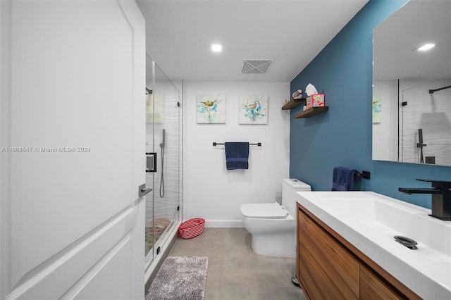 bathroom featuring vanity, toilet, and a shower with shower door