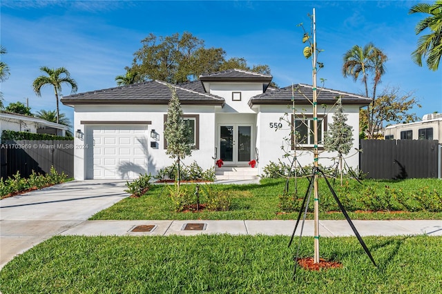 view of front of home featuring a front yard and a garage