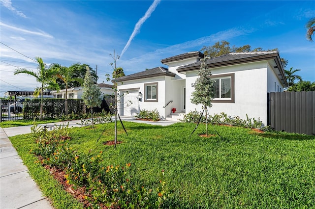 view of front of home with a garage and a front lawn