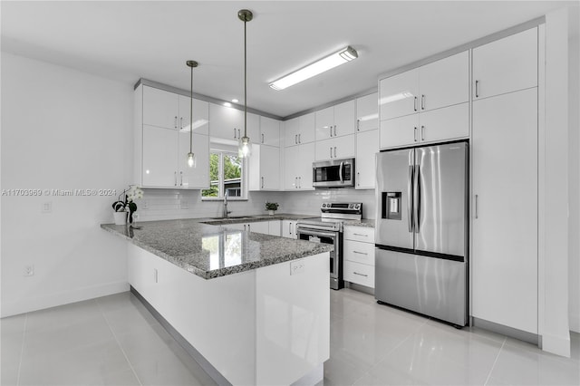 kitchen featuring white cabinetry, kitchen peninsula, pendant lighting, light tile patterned flooring, and appliances with stainless steel finishes