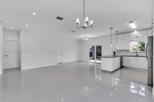 kitchen featuring appliances with stainless steel finishes, sink, light tile patterned floors, white cabinets, and hanging light fixtures