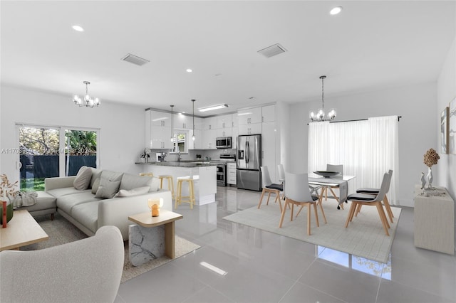 tiled living room featuring a notable chandelier and sink