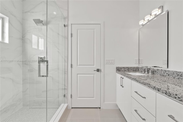 bathroom featuring tile patterned floors, vanity, and a shower with door