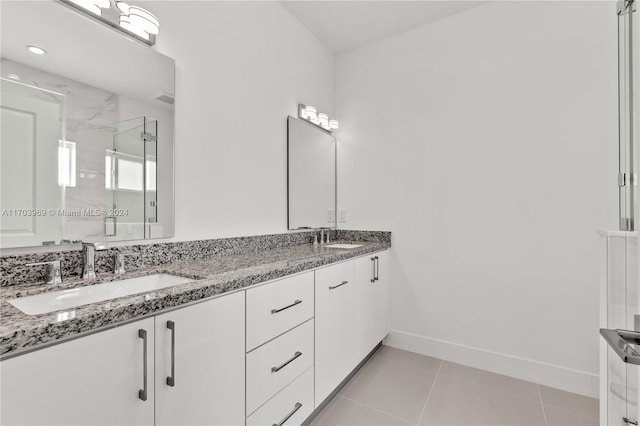 bathroom featuring tile patterned flooring, vanity, and a shower with door