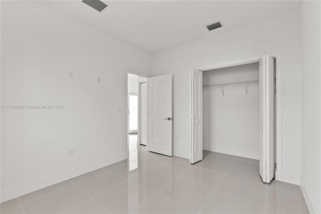 unfurnished bedroom with light tile patterned floors and a closet