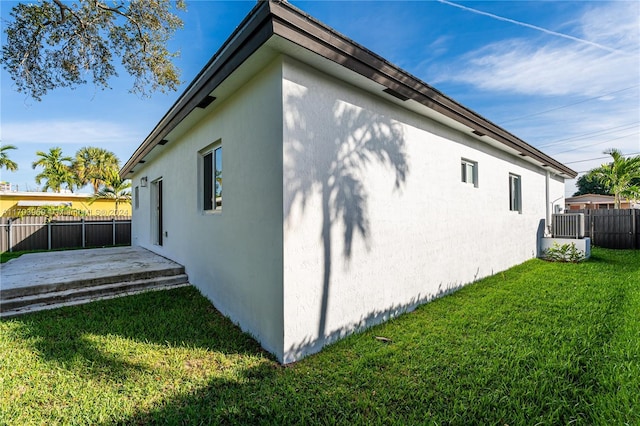 view of home's exterior with a patio and a lawn