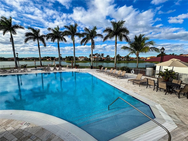 view of pool with a water view and a patio area