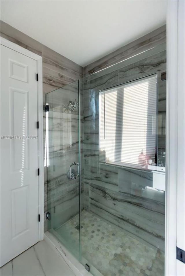 bathroom with a shower with door