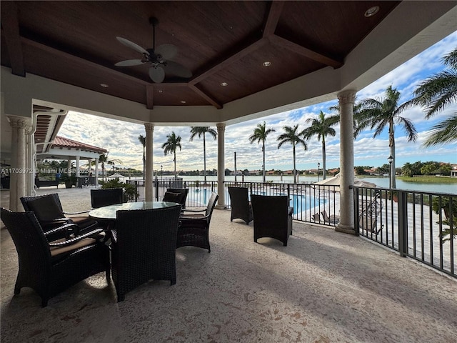 view of patio with a fenced in pool, ceiling fan, a water view, and a gazebo