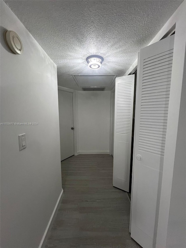 corridor featuring a textured ceiling and hardwood / wood-style flooring