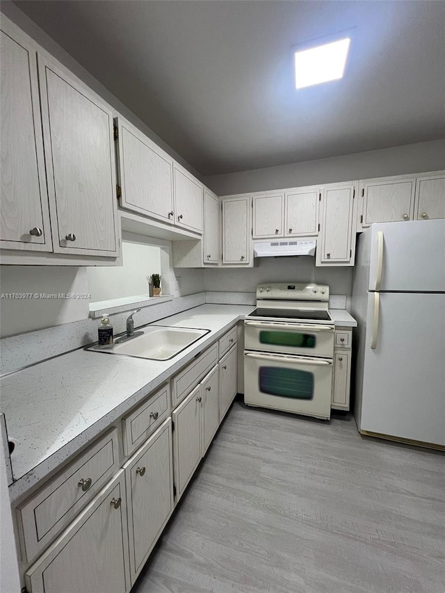 kitchen featuring light wood-type flooring, white appliances, white cabinetry, and sink