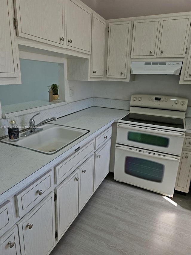 kitchen with white range with electric stovetop, light hardwood / wood-style floors, sink, and exhaust hood